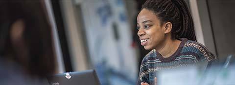 Person smiling and looking at a laptop