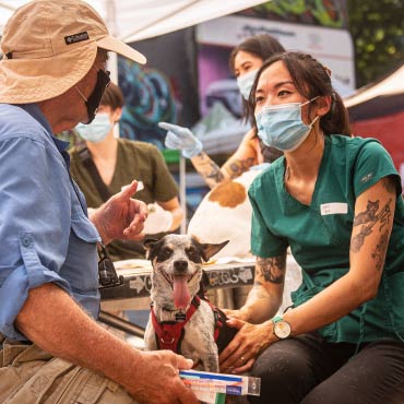 Two people sitting outside under a tent getting support