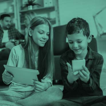 Two kids playing with tablet and phone