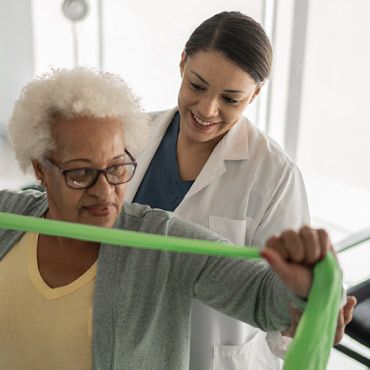 Patient performing resistance exercise with healthcare worker.