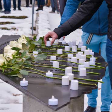 Candles and white roses at '14 Not Forgotten' ceremony