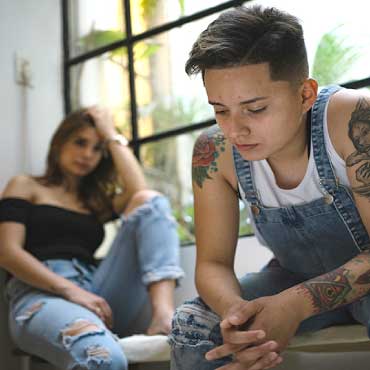 Couple sitting down looking sad and stressed