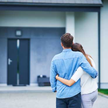 Couple standing in front of a house