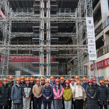 A group of researchers wearing hard hats at a building site