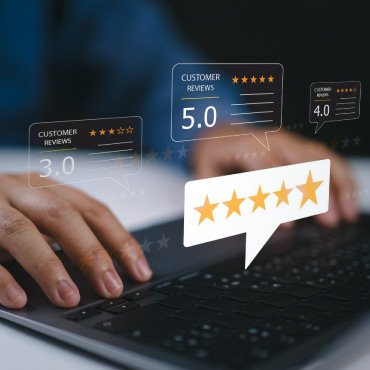 Close-up of a hand on a keyboard with multiple consumer review graphics floating above