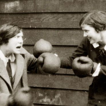 Two students playing around in boxing gloves, sometime between 1915 and 1925