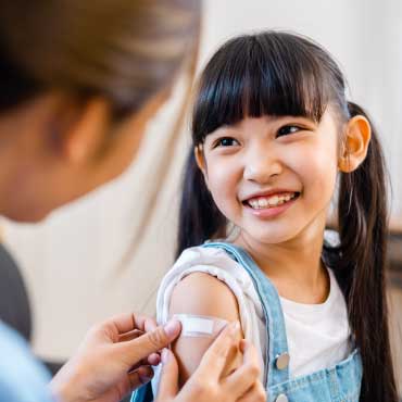 Child with a bandaid on their arm after getting a vaccine.