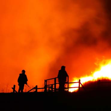 Two firefighters obervsering wildfires