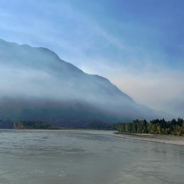 View of mountain and river with smokey skies