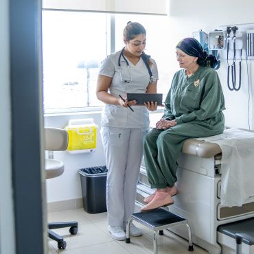 Health care worker showling tablet to a patient