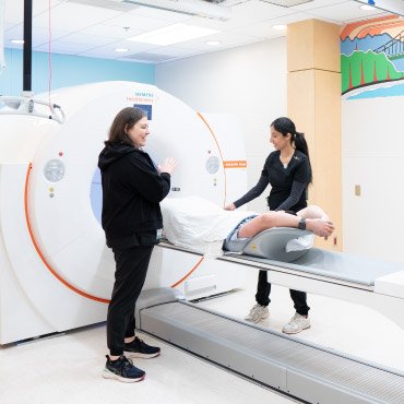 Erin Postlethwaite, PET Technologist, and Navjit Jabal, PET/CT Technologist, guide a patient through a PET/CT scan at BC Cancer – Vancouver.