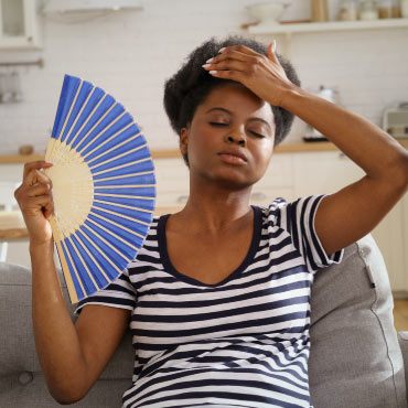 Person fanning themself to cool down from heat.