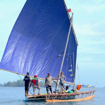 People on a sailboat with a map of Australia and New Guinea in the background