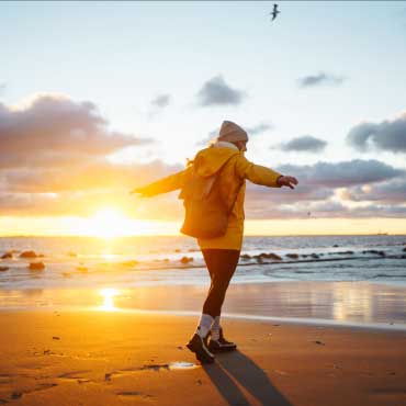 Person walking on the beach during sunset